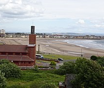 Image of a photograph, taken from the Cannon Hill in Ardrossan of the town’s Catholic church, and the sea in the background to illustrate the post