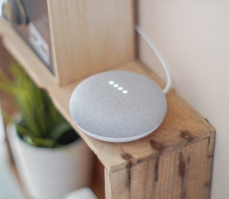 Google Home Mini, sitting on shelf. Harlow Journey Article about Google Home Please Don’t Talk to Me That Way!