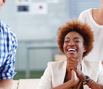 Diverse team mates in a business setting, sitting at a table and having a conversation.