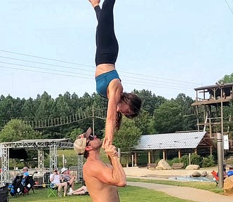 This photo is of me executing an acroyoga move called a standing hand-to-hand, which is where the flyer (me) performs a handstand on a base’s hands. The base is standing up.