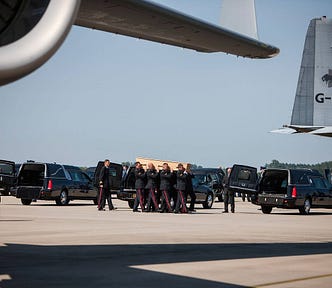 Image of a coffin of one of the MH17 victims carried to a hearse at Eindhoven airport