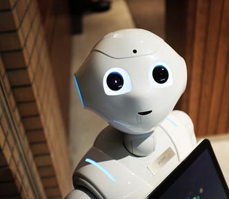 A photo of a cute robot taken from above with the robot looking up at us