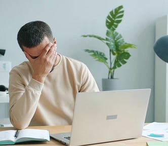 A man working on his computer shows clear frustration by placing his hand on his face. | Photo by Vitaly Gariev on Unsplash