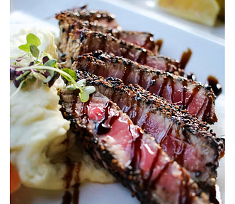 Rare steak that is sliced into strips, plated and drizzled with steak sauce