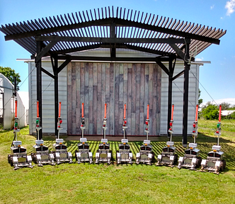 A row of the robots lined up in front of a shed.