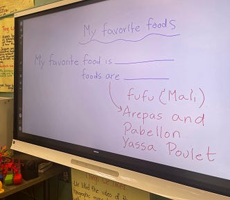 A classroom whiteboard with sentence frames about food for multilingual learners.
