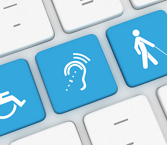 A white computer keyboard with three blue keys featuring accessibility icons: a wheelchair symbol, a hearing aid, and a person with a cane.