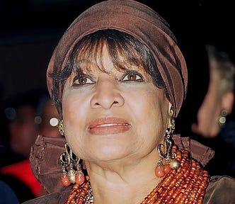 Civil rights activist Delores Tucker is pictured at a 1996 Washington D.C. Black caucus event. Tucker is wearing a brown head scarf, red lipstick and gold and red dangling earrings.