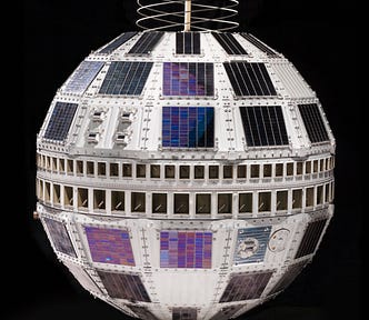 Color photo against black background of Telstar satellite