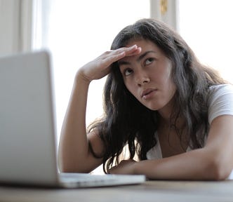 Young annoyed freelancer using her laptop at home
