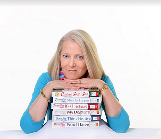 Woman with blond hair in turquoise top leans on Chicken Soup for the Soul books