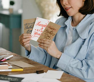 A Woman Holding Assorted Greeting Cards