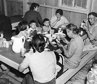 Manzanar, Calif., April 1942: Several generations of the Nakamura family have mealtime at the Japanese war relocation center. Source: April Monroe, daughter of Minoru Nakamura and granddaughter of Asaye Nakamura, February 2023