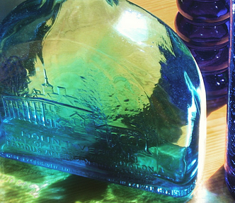 Three blue bottles in a still life with light streaming through them