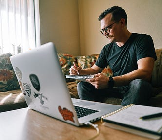 Mustached and spectacled man writing