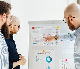 Three men discussing a finance report