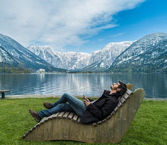 man sitting on brown wooden chair