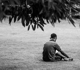 Man sitting alone, posture indicates he’s tired or sad.