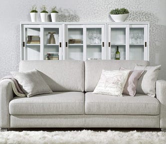 A couch with pillows and an afghan.