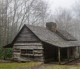 A weathered cabin in a misty forest