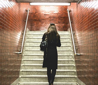 A solitary woman entering a train station.