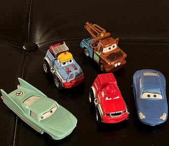 Five toy cars based on the characters in the animated movie Cars.