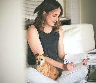 dani and her tan chihuahua bambi sitting on a bed