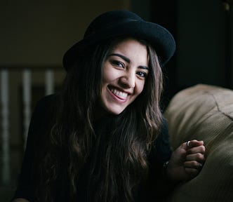 A pretty young lady smiling brightly.