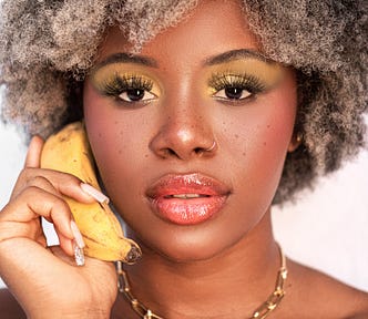 Stylish Black woman having conversation on banana. Clearly the banana is an essential tool to build your writing business.