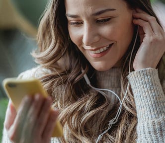 A woman using her earphones plugged into her phone to talk or listen.