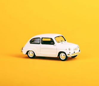 A miniature Volvo car on a yellow background