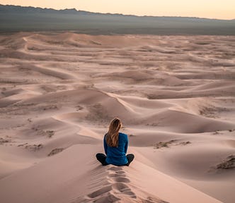 Finding your independence. A woman sitting alone in a desert.