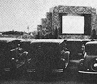 Several cars facing a large outdoor movie screen