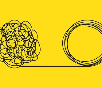 On a bright yellow background, a squiggly mess of black scribbles straightens out into a line leading into that same squiggly mess, this time rounded out into overlapping and neatly-arranged circles.