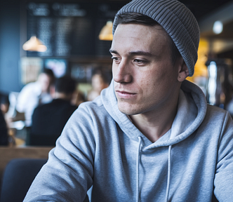 Man in a beanie at a coffee shop — This Boring Article Type Makes Me $100 Per Day