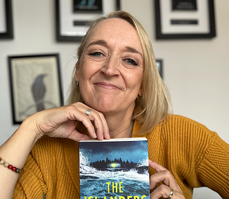 Author Caroline Mitchell holding her book, The Islanders