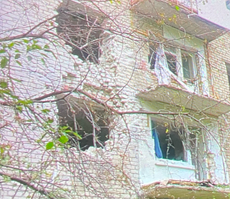 Side of a building with 2 gaping holes caused by a bomb