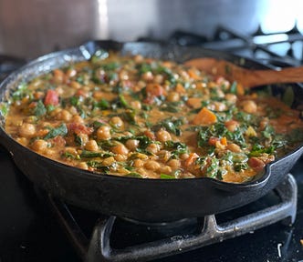 Cast iron pan full of Chana Saag, which is a spinach chickpea curry.