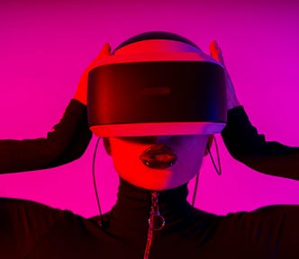 pink tone contrast photo of woman wearing futuristic headset around eyes