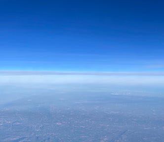 Blue sky above the cloud line with the earth far below.