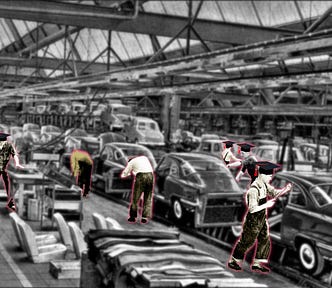 A black and white photo of a early 20th century auto assembly line. The assembly line workers have been limned in red halos and each sports a black college mortarboard.