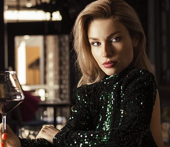 Attractive woman staring seductively while holding a glass of wine.