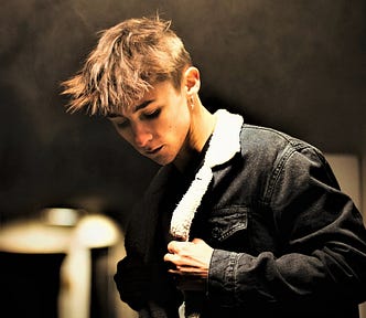 moody photo of young man with blonde hair looking down