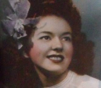 Beautiful vintage hand-tinted photo of woman with flower in her hair