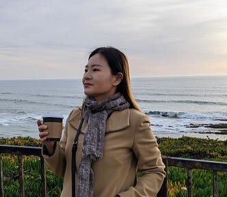 Felicia Wu holds a cup of coffee looking ahead on the Half Moon Bay coastline.