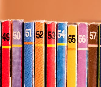 A series of well-worn books with numbers at the top 48 through 58.