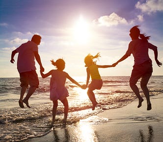 A family jumping together on a beach