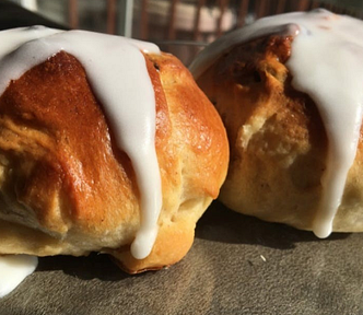 two hot cross buns with icing on a plate