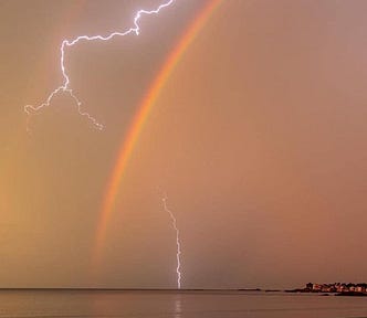 stunning photo of a rainbow and lightning in the sky