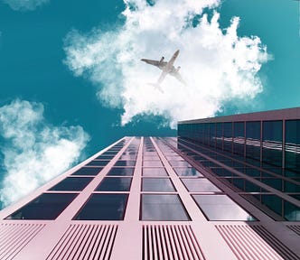 An Airplane Flying Over The Buildings